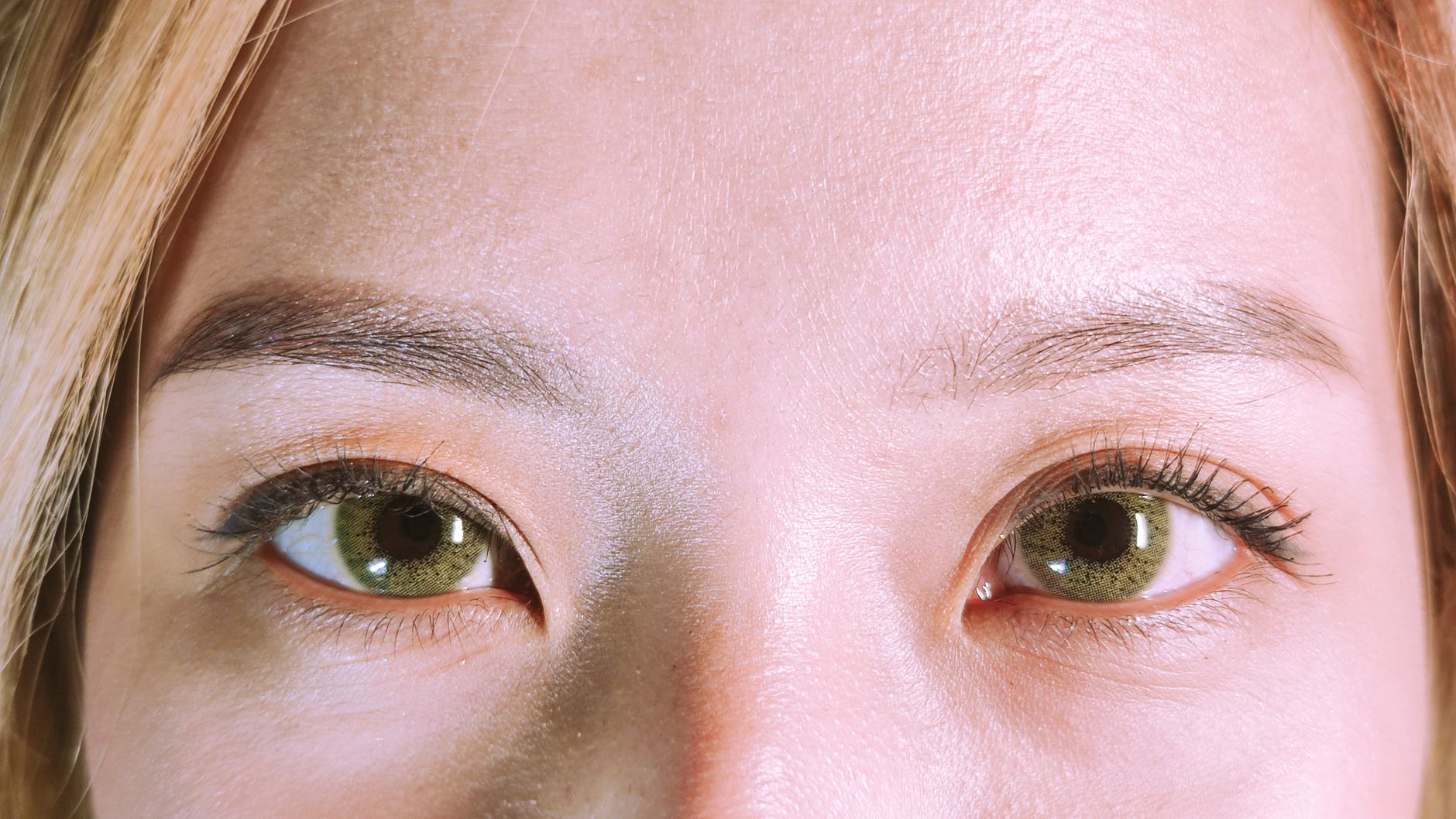 Detailed close-up of a person's eyes, showcasing natural makeup and skin texture.