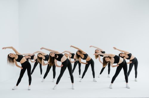 Free A group of women performing synchronized exercise in a bright studio setting. Stock Photo