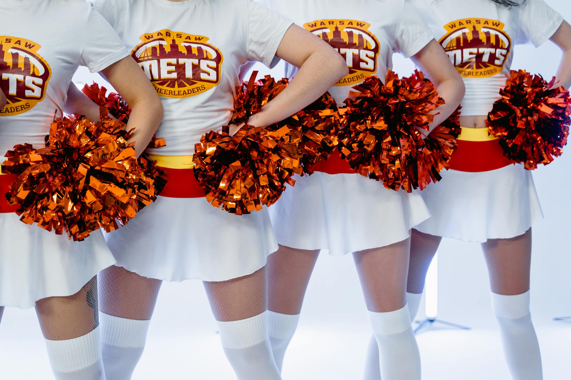 Women in White Shirts and Skirts Holding Pompoms