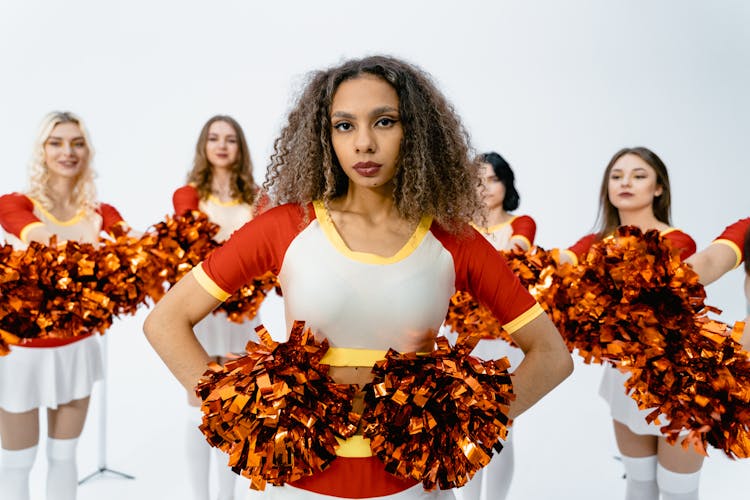 A Cheerleader With Curly Hair Leading A Squad