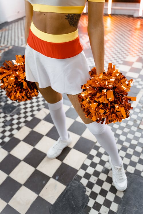 A Woman in Cheerleading Uniform and White Shoes Holding Pompoms