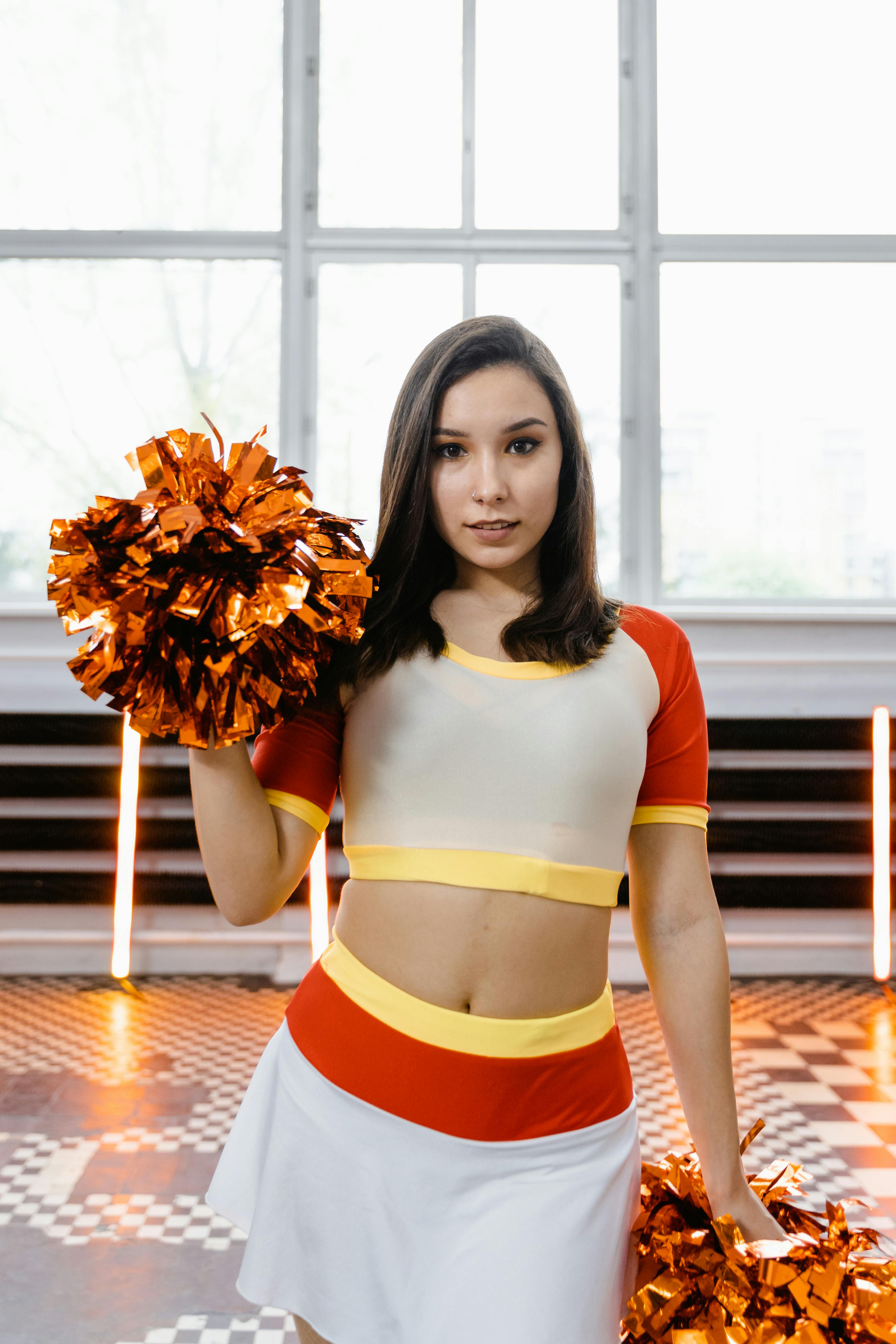 A Beautiful Woman in a Cheerleader Uniform Holding Pompoms Free