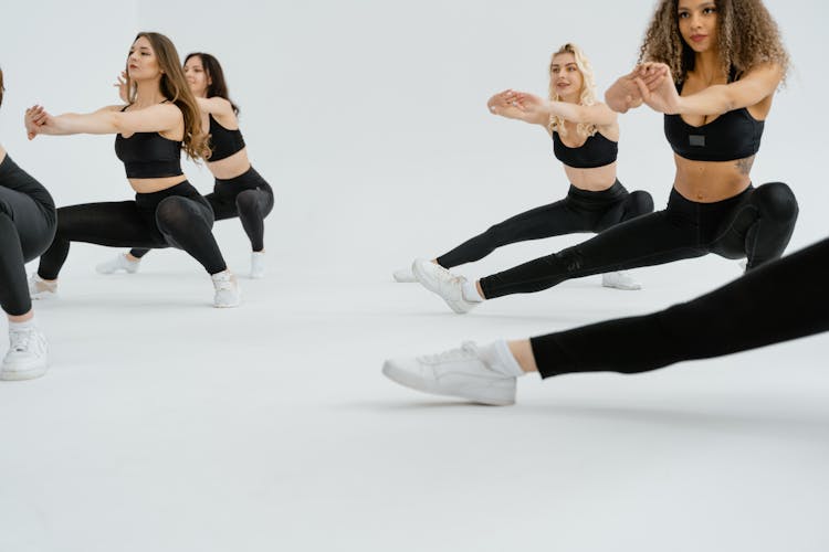 Group Of Women In Black Activewear Doing Stretching Exercise