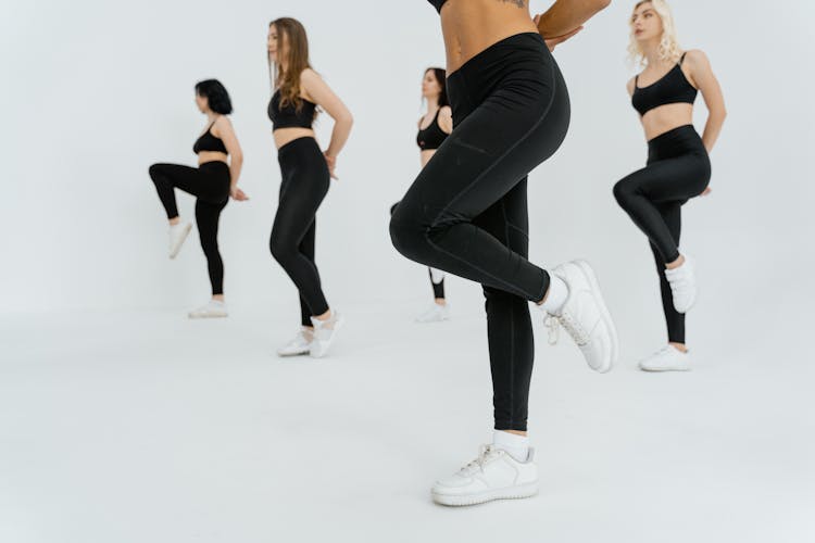 A Group Of Women In Black Sportswear Doing Exercise