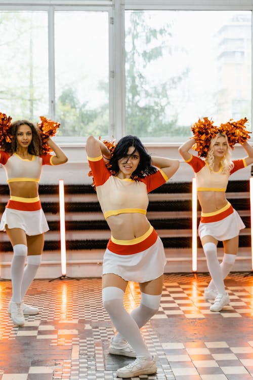 Three Women in Cheerleading Uniform Holding Pompoms Dancing