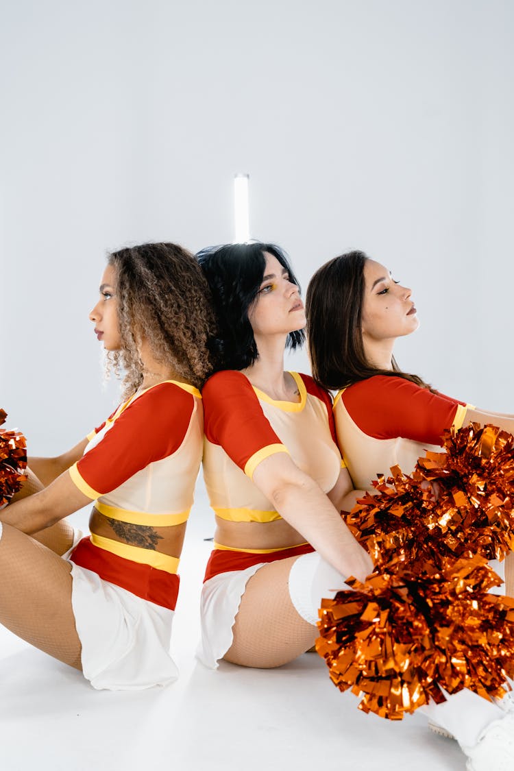 Three Cheerleaders Sitting On The Floor