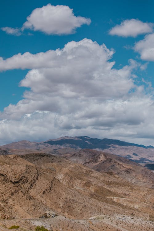 An Aerial Photography of a Mountain Under the White Clouds and Blue Sky