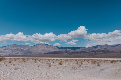 A desert landscape with mountains in the background · Free Stock Photo