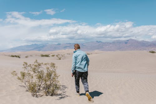 Free A Man Walking on the Desert Sand Stock Photo