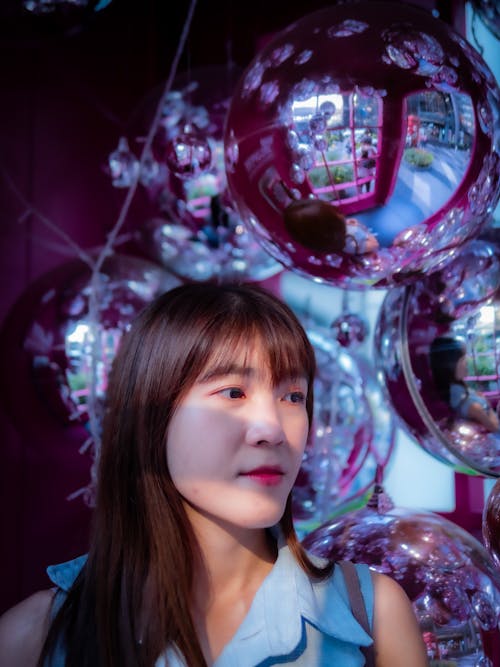 Woman in Blue Shirt Standing Beside Balloons