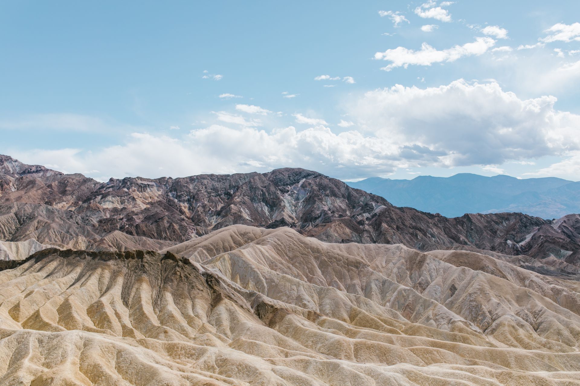 A breathtaking view of rocky hills in an arid desert landscape under a blue sky.