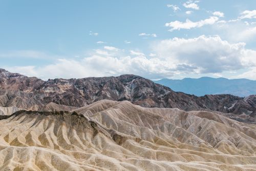 Free A breathtaking view of rocky hills in an arid desert landscape under a blue sky. Stock Photo