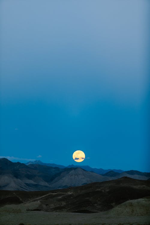 Free Moon on Clear Sky over Hills in Evening Stock Photo
