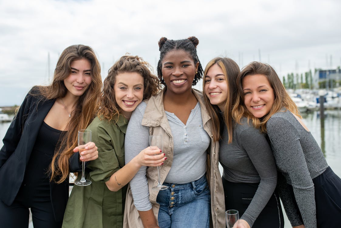 Free A diverse group of cheerful women smiling and enjoying their time by the marina in Portugal. Stock Photo