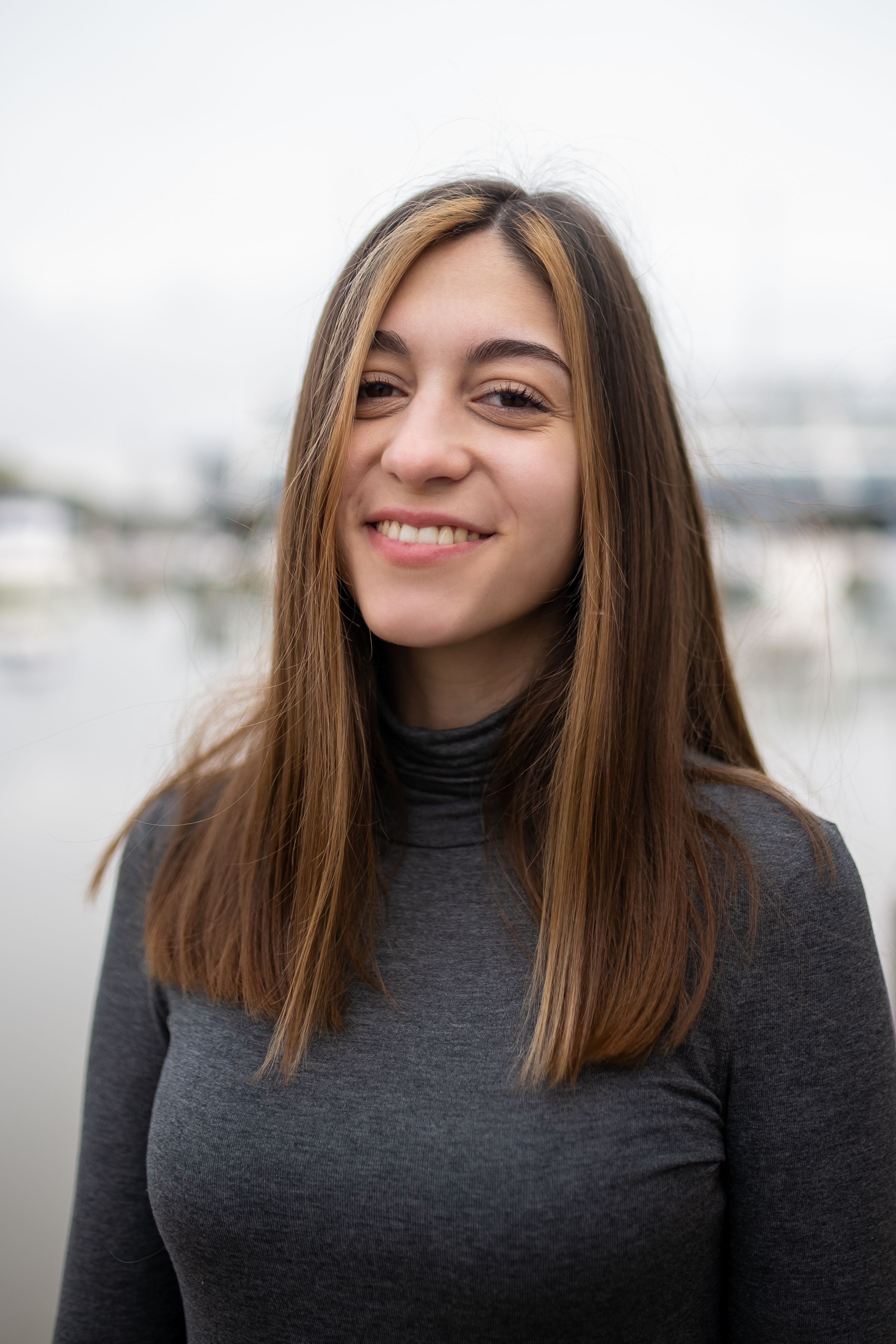 Portrait of a smiling woman outdoors in Portugal with a blurred background.
