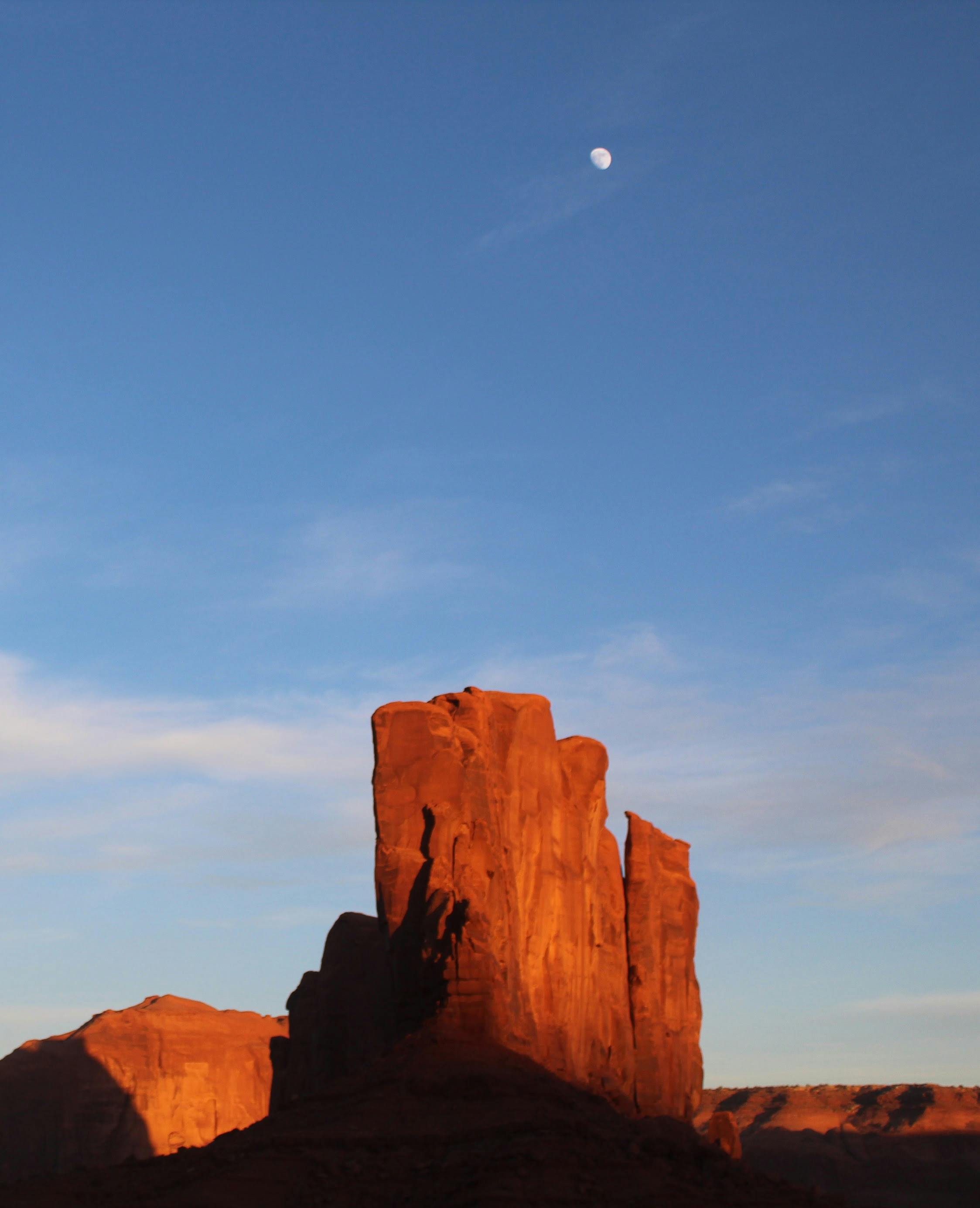 日出时，月亮可见，纪念碑谷的风景捕捉到了标志性的红色岩石结构