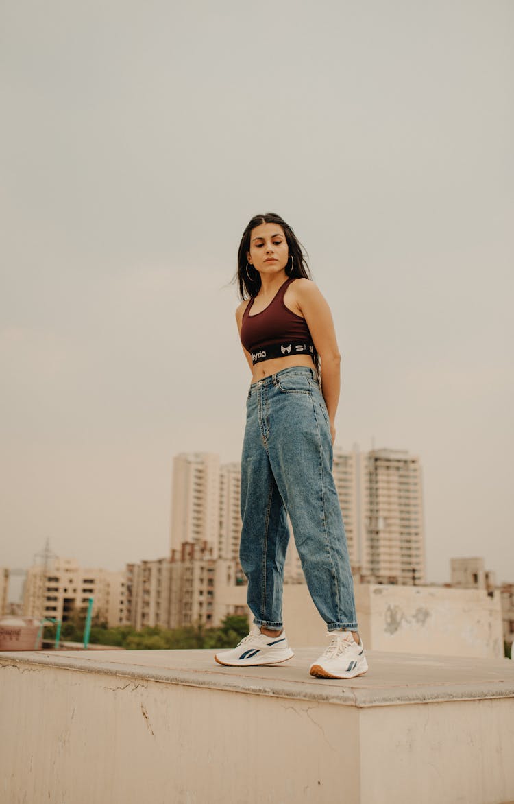 Stylish Young Woman Standing On Rooftop In City