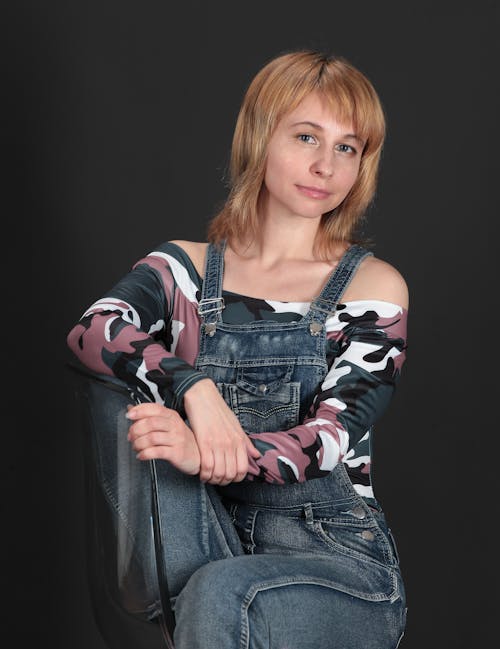 A Woman in Denim Jumper Sitting on the Chair