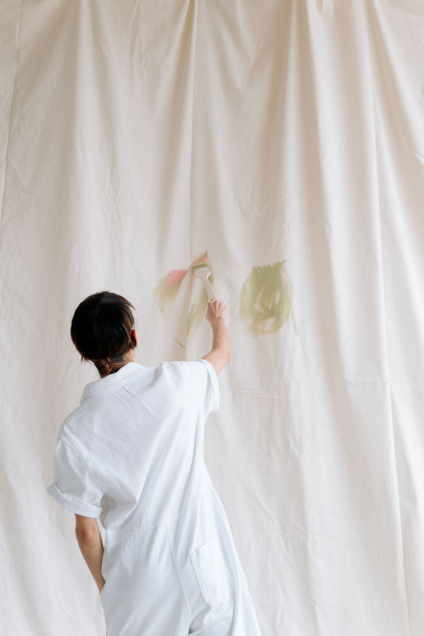 An artist painting a large white canvas