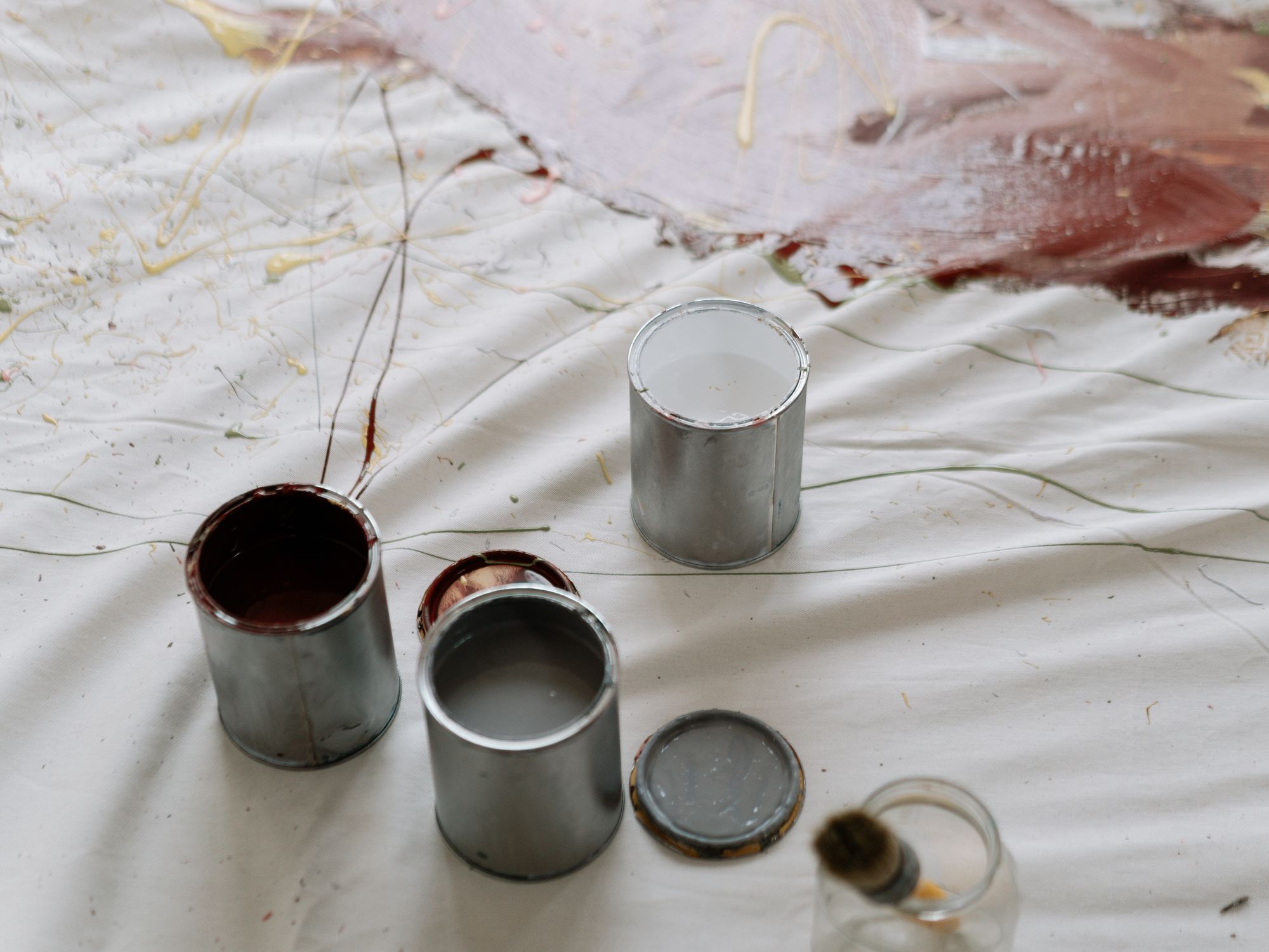 Open paint tins ready on a protected floor before decorating