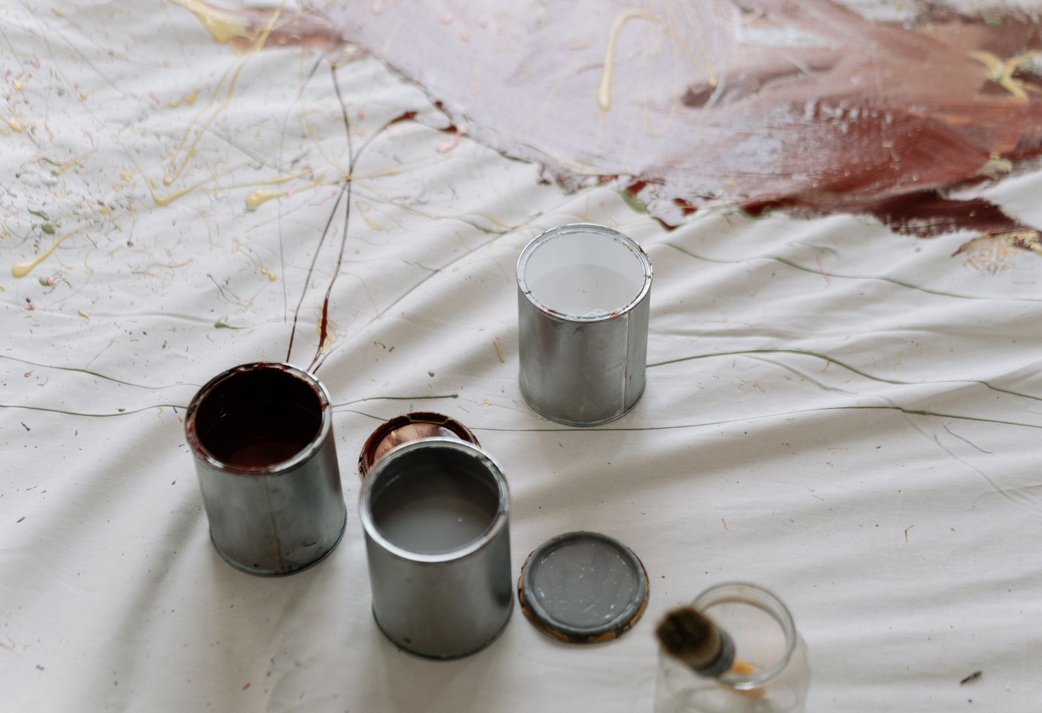 Open paint tins ready on a protected floor before decorating