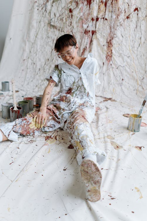 A Boy in Coveralls Splattered With Paint
