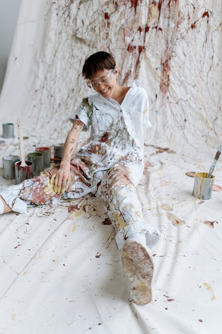 A Boy In Coveralls Splattered With Paint