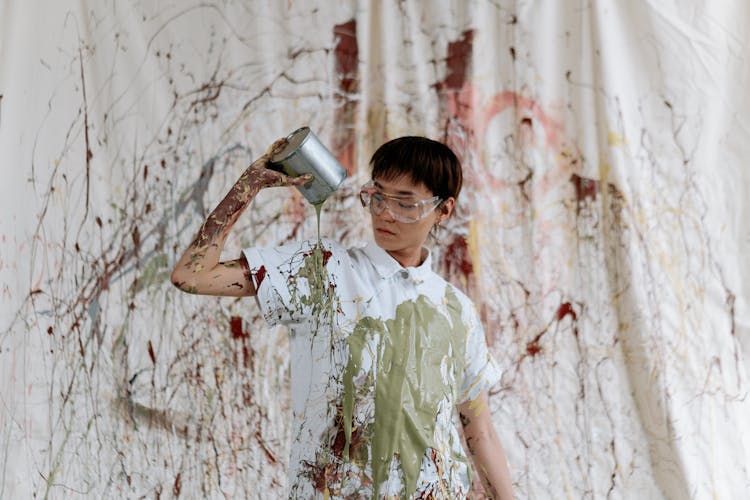 A Woman In White Top Pouring Paint