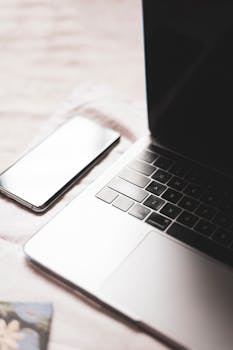 Minimalist close-up of laptop and smartphone on desk, ideal for technology themes.