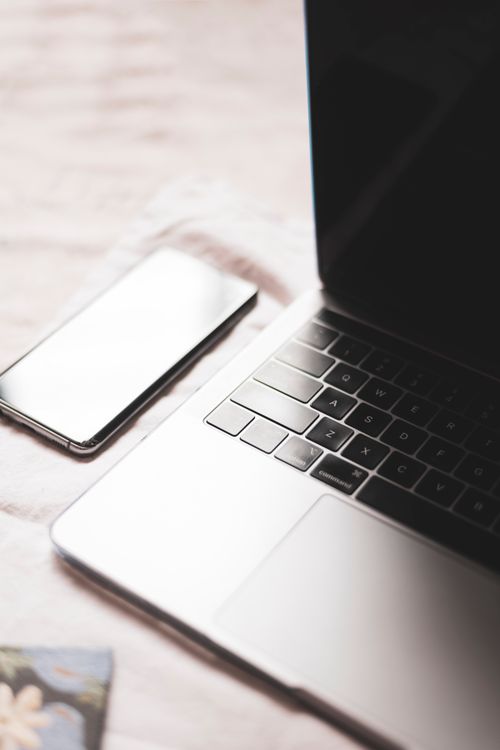 Free Minimalist close-up of laptop and smartphone on desk, ideal for technology themes. Stock Photo