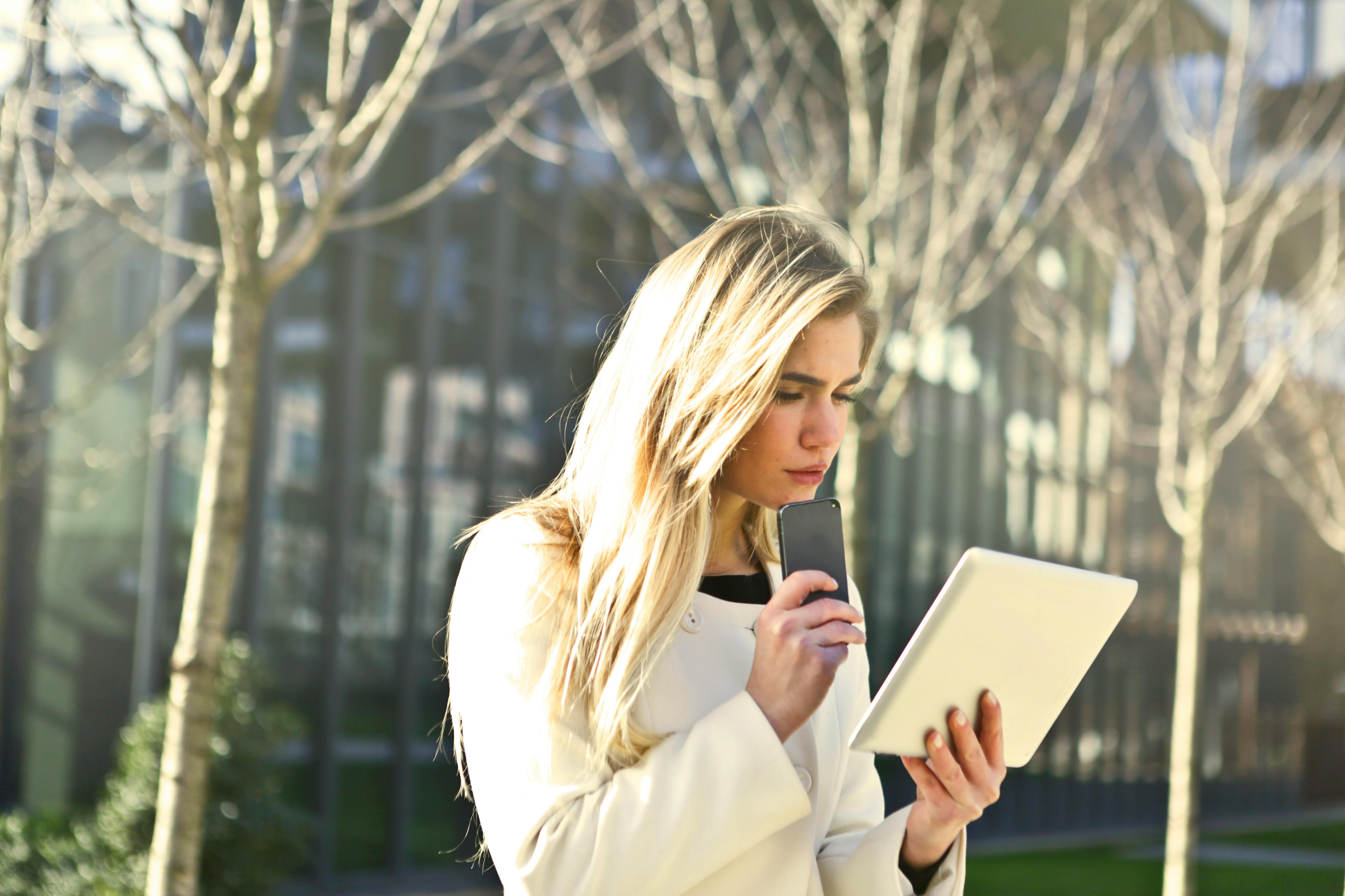 brown haired woman holding a white wireless device