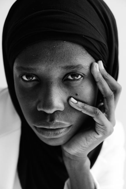 Striking black and white portrait of a contemplative woman wearing a hijab, showcasing deep emotion.