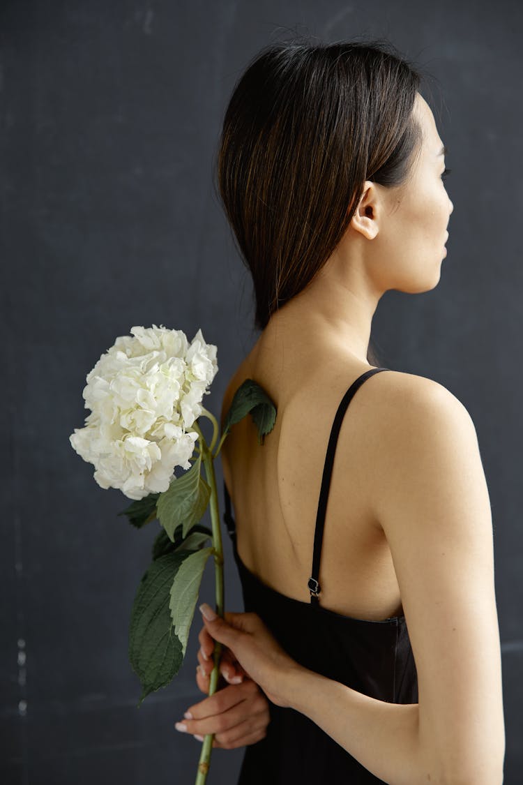 Woman Hiding Flowers Behind Back