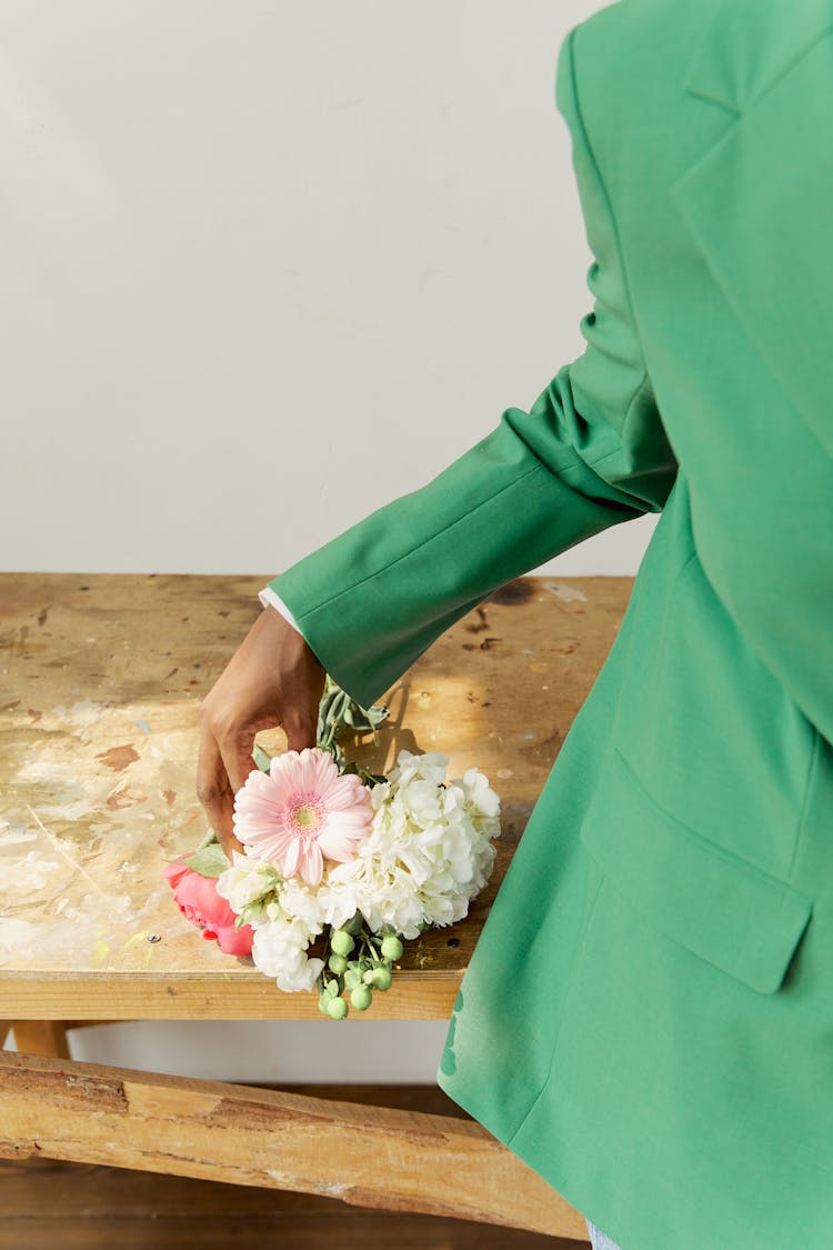 Female Hand In Suit Holding Flowers