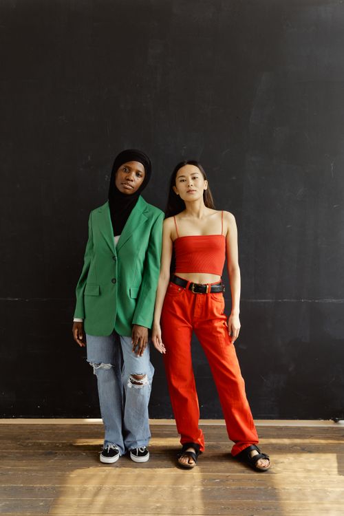 Free Two women showcasing casual and modern fashion in an indoor setting. Stock Photo