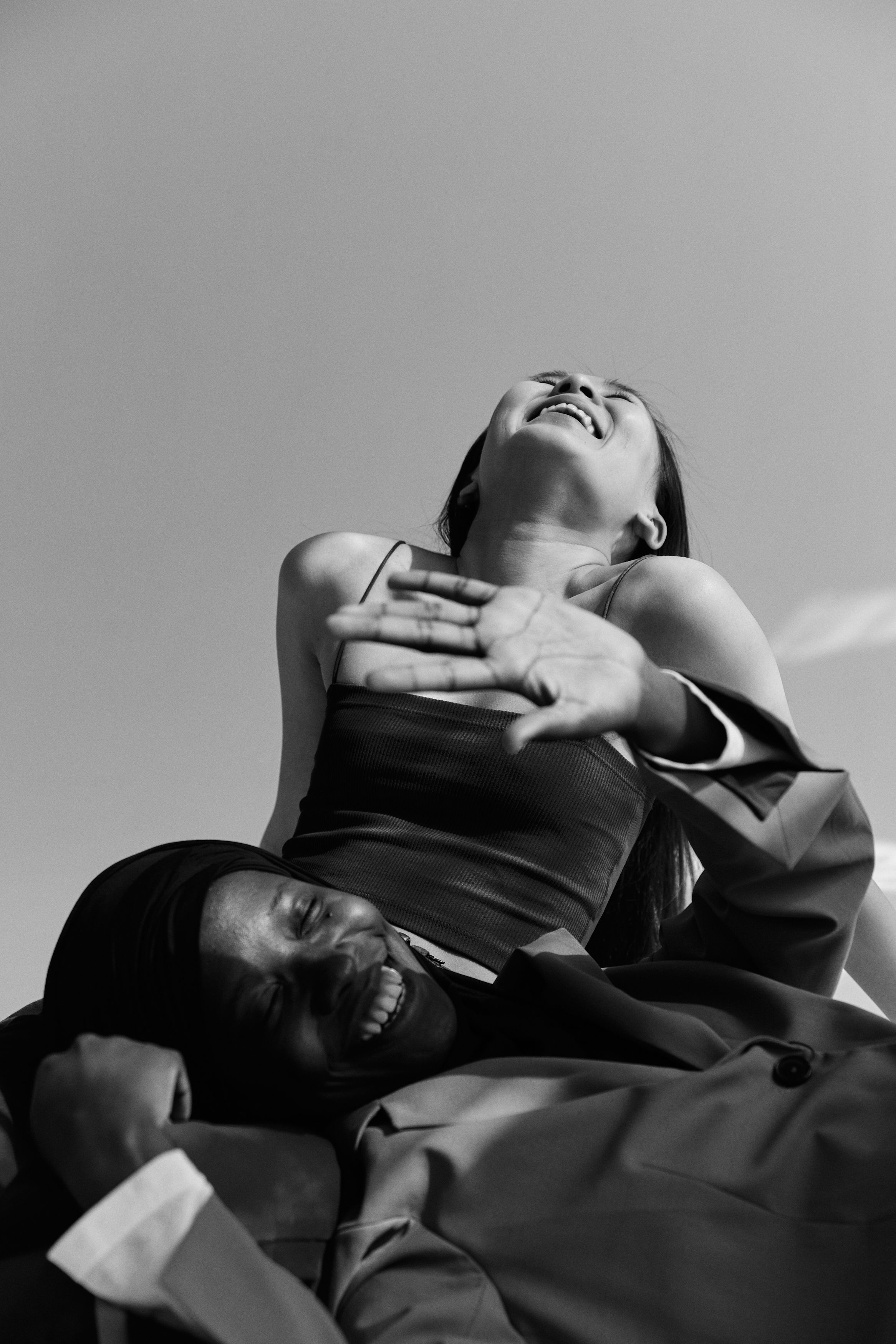 A joyful black and white portrait of two women laughing together.