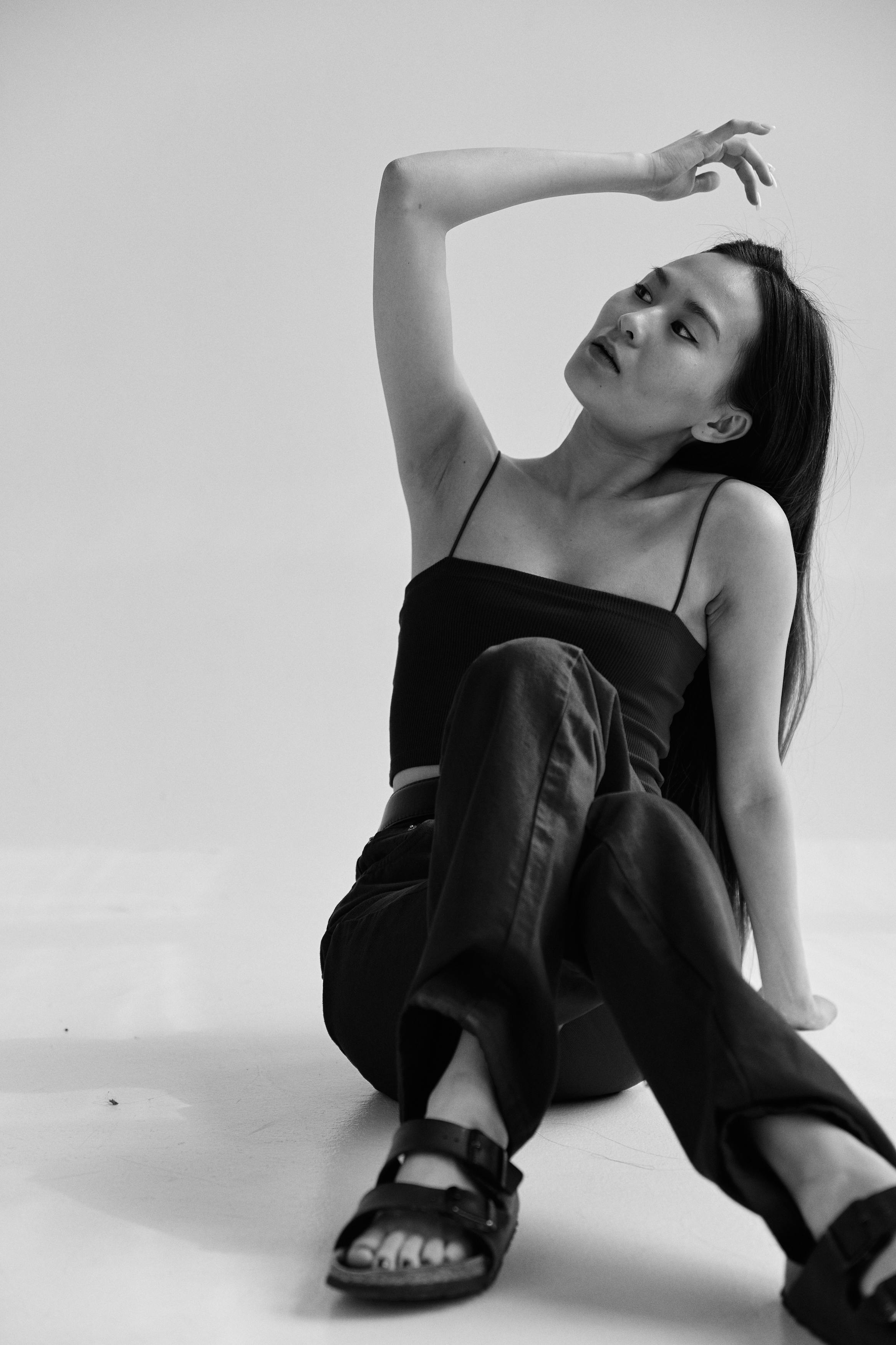 Artistic black and white portrait of a seated woman in casual attire, exuding modern elegance.