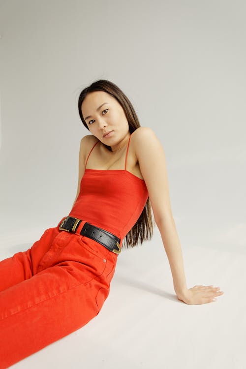 Woman in Red Spaghetti Strap Top Sitting on the Floor