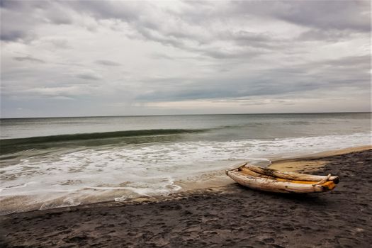 A serene seascape featuring a beached wooden raft on a peaceful Indian shore.