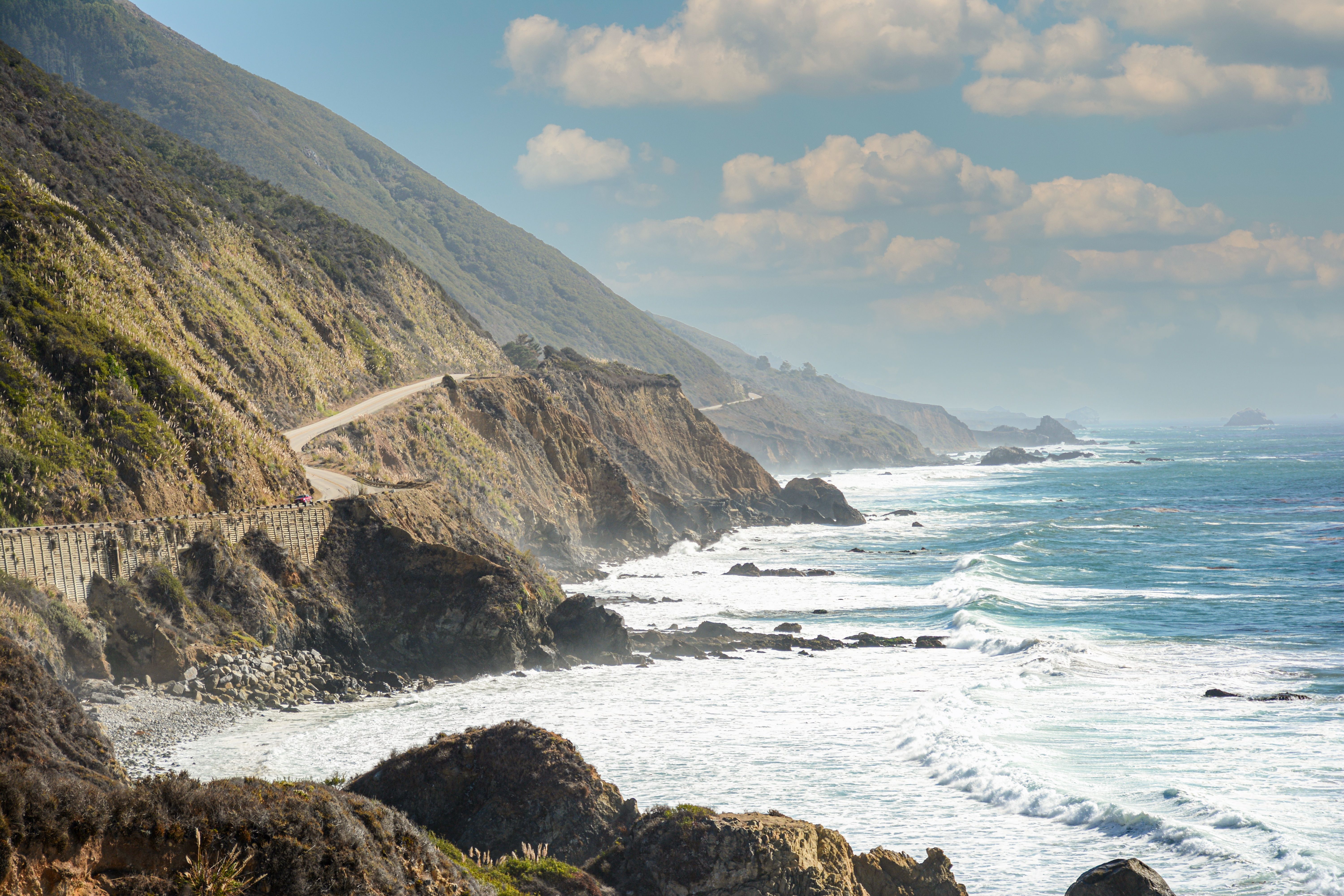 Captivating view of California's coastal highway along the rocky shore with ocean waves crashing. Captivating view of California's coastal highway along the rocky shore with ocean waves crashing.