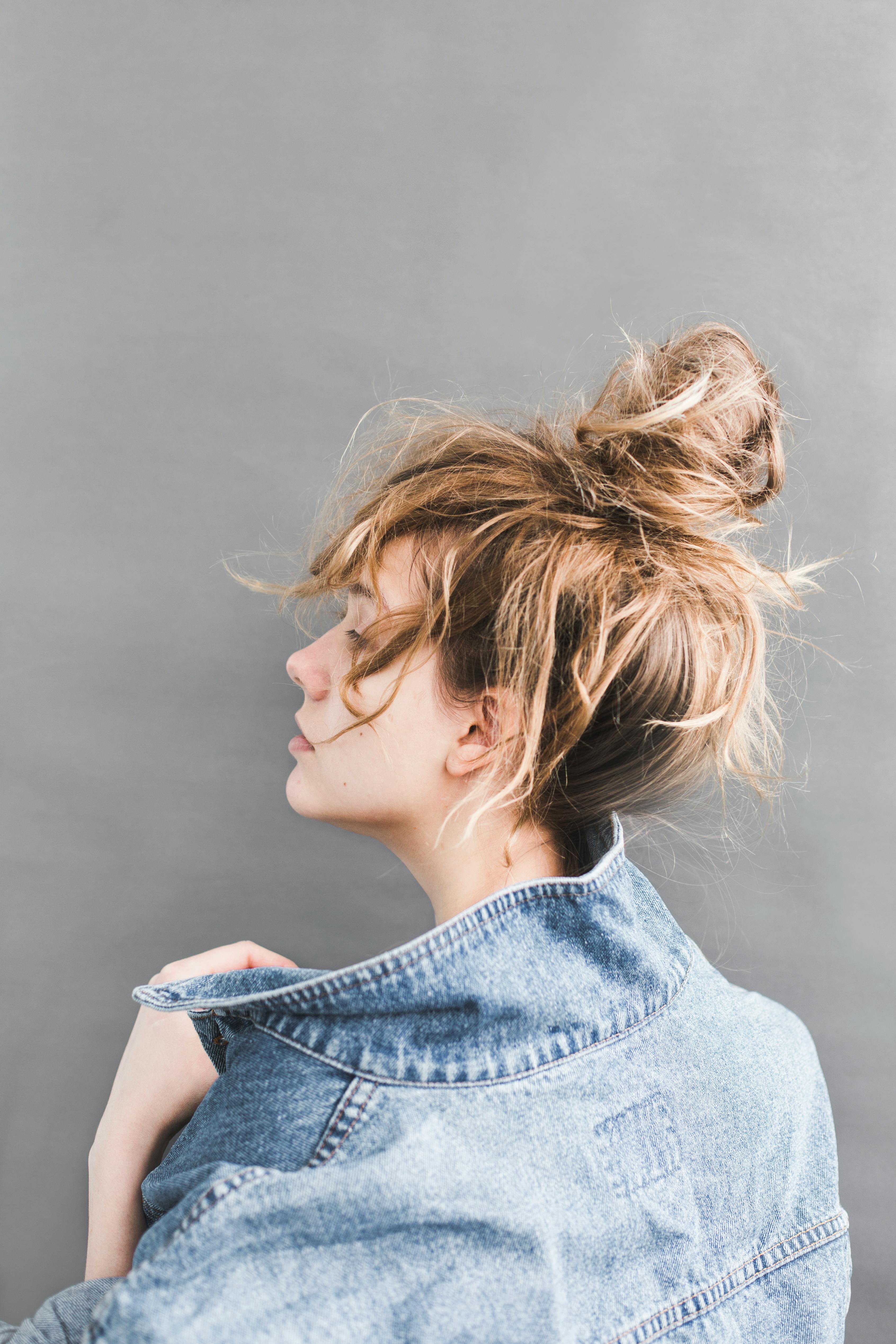 Back view of a woman holding her denim jacket. | Photo: Pexels