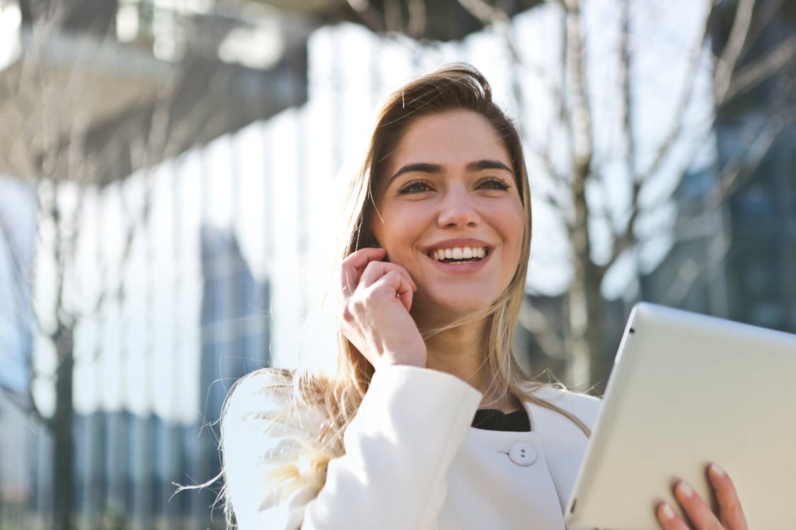 Free Woman In White Blazer Holding Tablet Computer Stock Photo