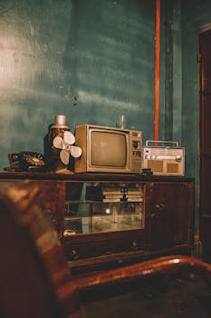 A nostalgic vintage setup featuring a retro TV, radio, and classic furniture.