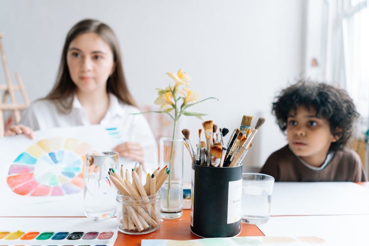 Teacher And Her Student Sitting At The Table