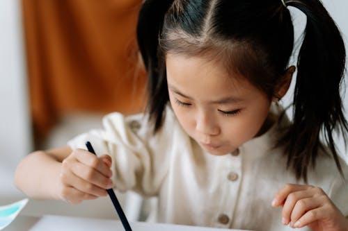 A Close-up Shot of a Young Girl Painting