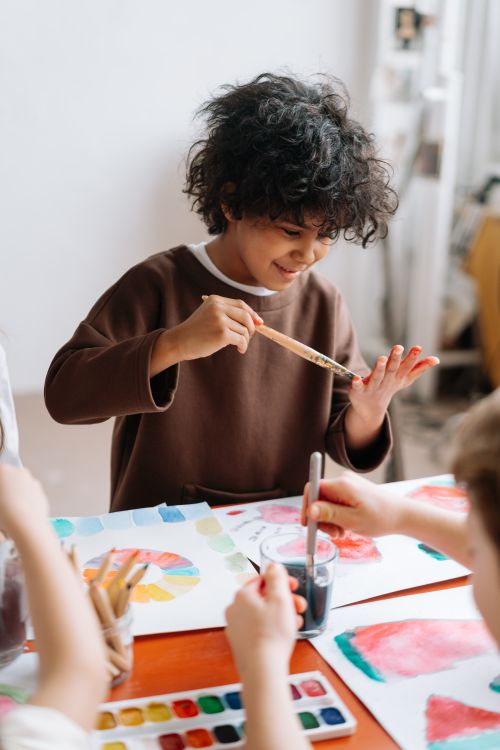 A smiling boy with paint on his hands during art time