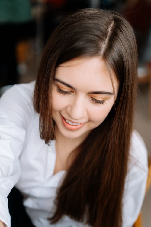 Free Close-up portrait of a smiling young woman in a white shirt. Stock Photo