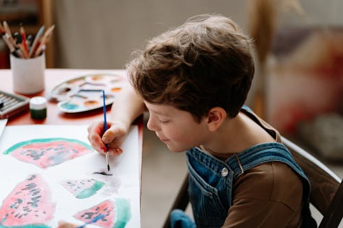 Young Boy Wearing Jumper Painting on a Paper