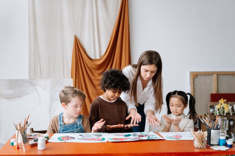 Children And A Woman Looking At Their Palms