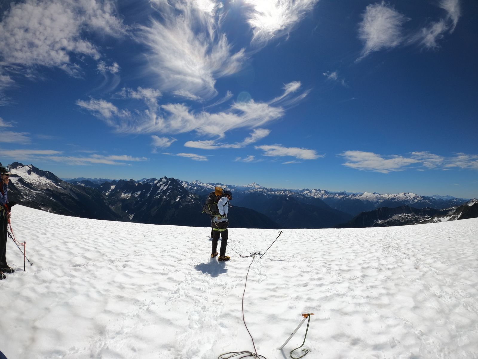 Two climbers on a snowy peak under a blue sky